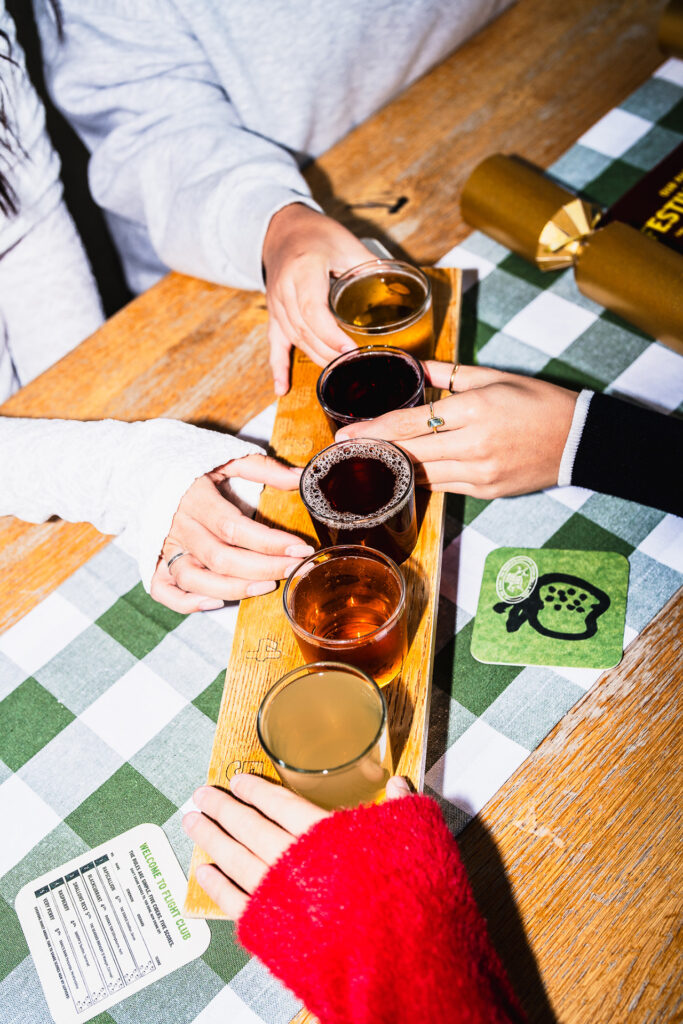 A flight of five Stable ciders on a wooden board at the bar